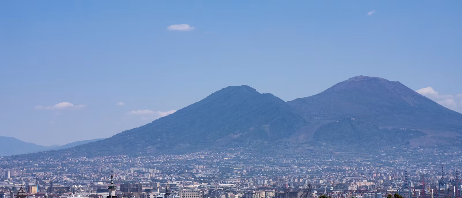 晴天里，维苏威火山压在那不勒斯的屋顶之上